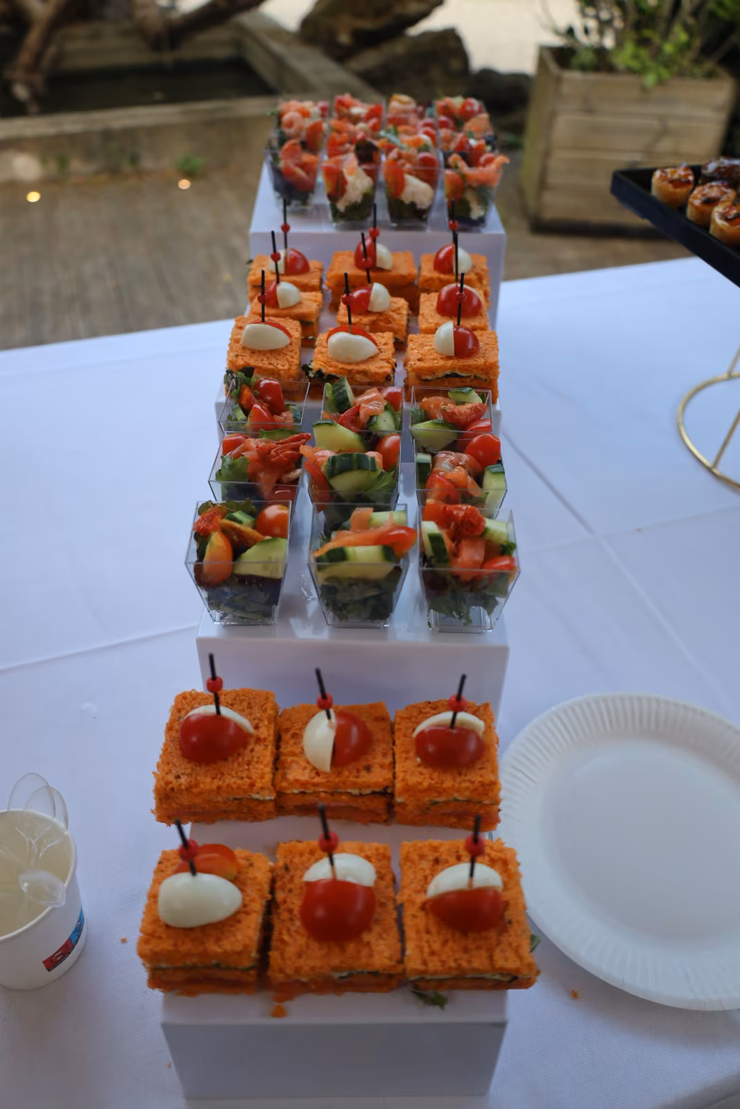 Présentoir en escalier de verrines de crudités et de canapés à l'œuf et à la tomate cerise