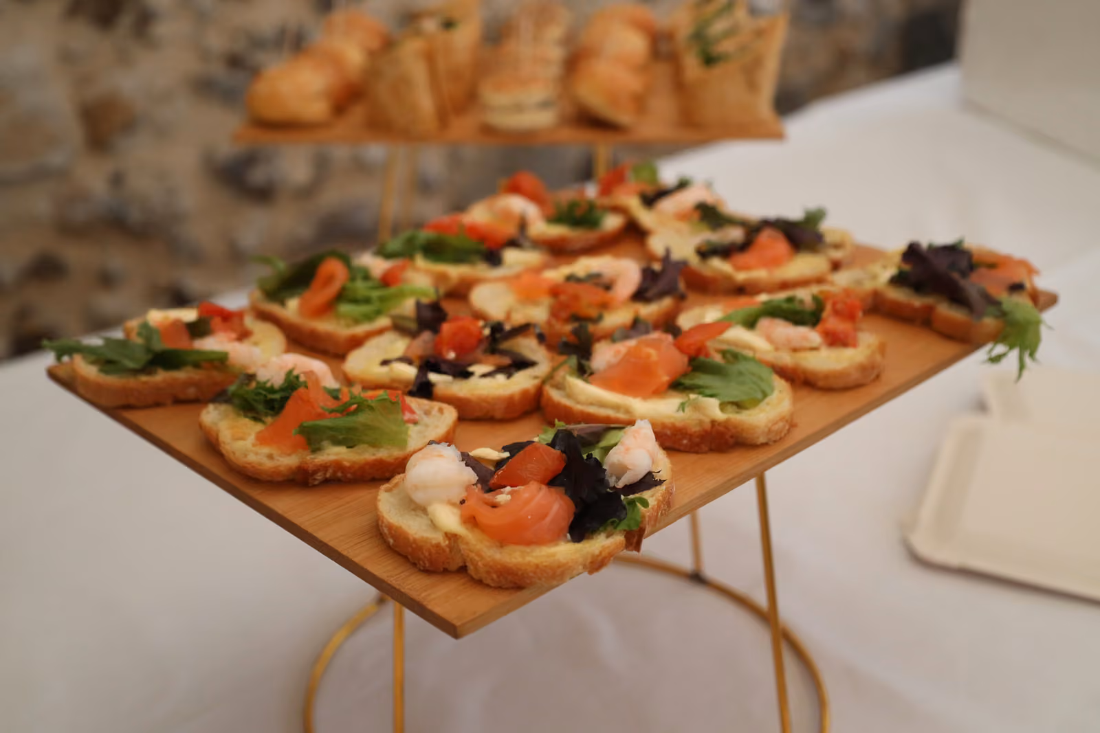 Toasts au saumon fumé, tomates confites, mozzarella et jeunes pousses sur un plateau en bois